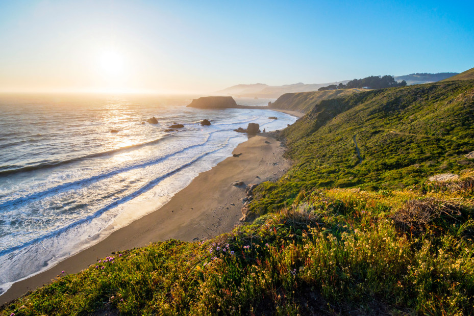 Sunset over the Pacific Ocean overlooking Goat Rock and a sandy beach.