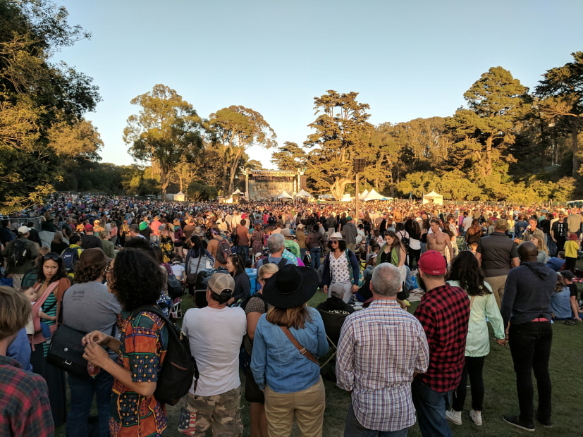 A large crowd stands in front of the Hardly Strictly Bluegrass stage.