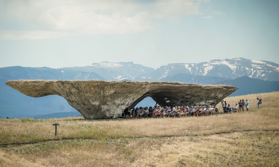 The Domo, a large-scale rock sculpture, features a flat surface on top and a carved area for audience seating below.