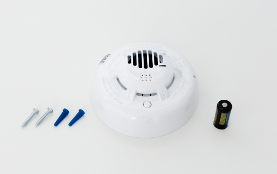 a carbon monoxide detector, a lithium battery, screws and wall anchors