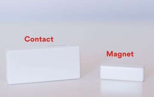 One contact (the larger piece) and one magnet (smaller piece) of a entry sensor
