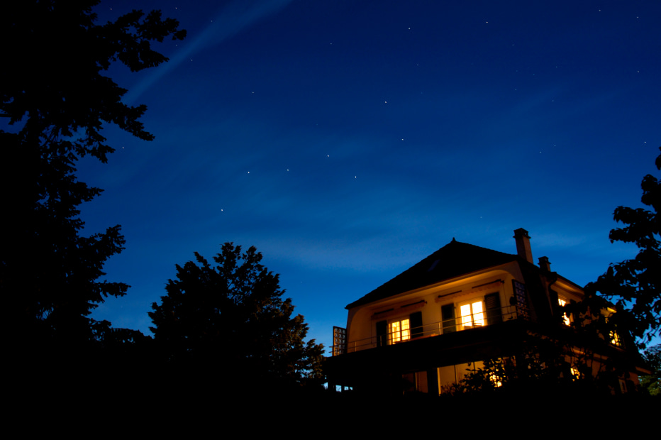 Stars come out over a home lit up at night.