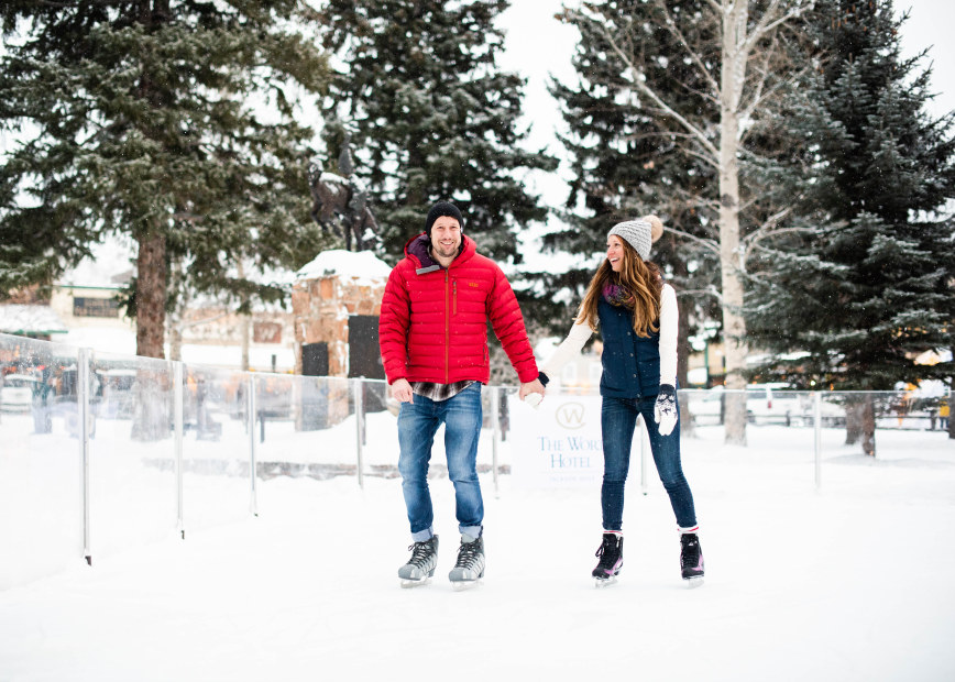 A couple ice skate in Jackson Hole town square in Wyoming.