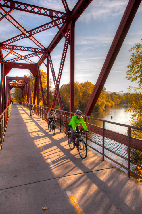 Bicyclists crossing Boise River on old railroad trestle on the Boise Greenbelt in Idaho.