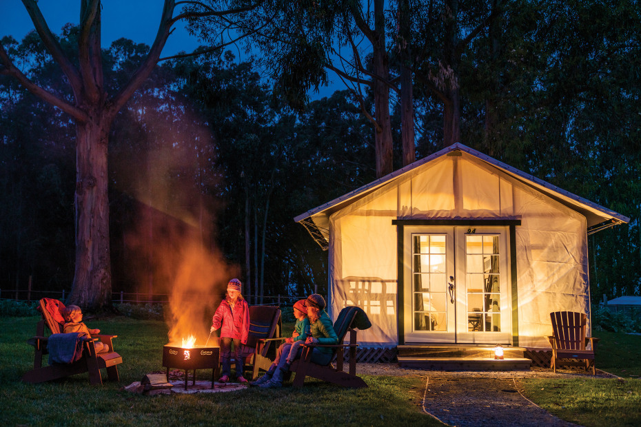 Campers sit by the fire pit outside a glamping tent at Costanoa in Northern California.