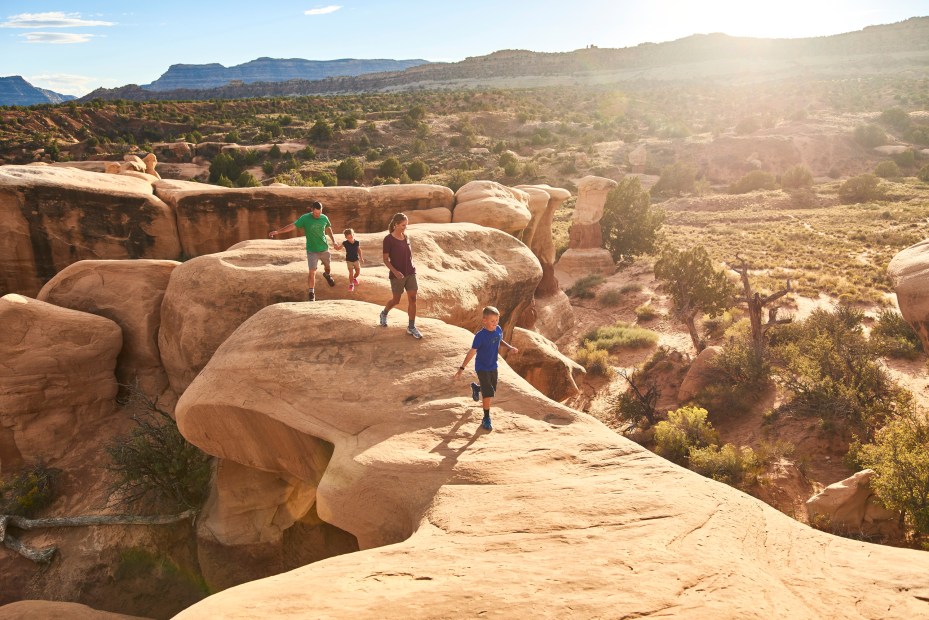A family hiking Devils Garden in Grand Staircase Escalante National Monument in Utah.