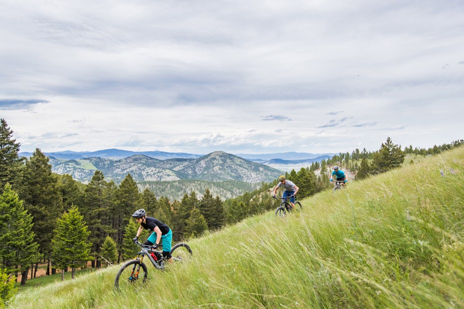 Three mountain bikers ride downhill on the South Hills Trail System.