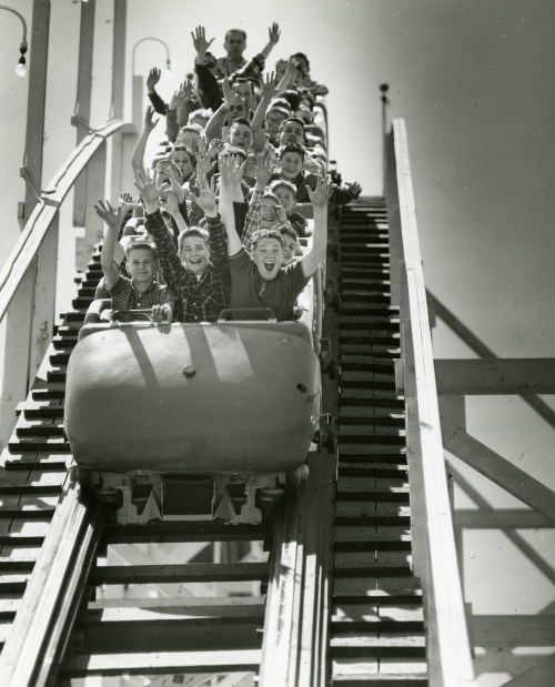 Riders put their hands in the air on the Santa Cruz Beach Boardwalk's Giant Dipper in 1958.