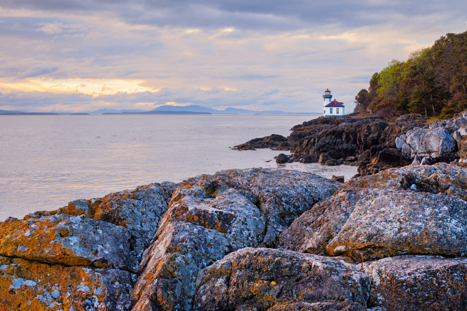Lime Kiln Lighthouse on San Juan Island in Washington on a party cloudy day at sunset.