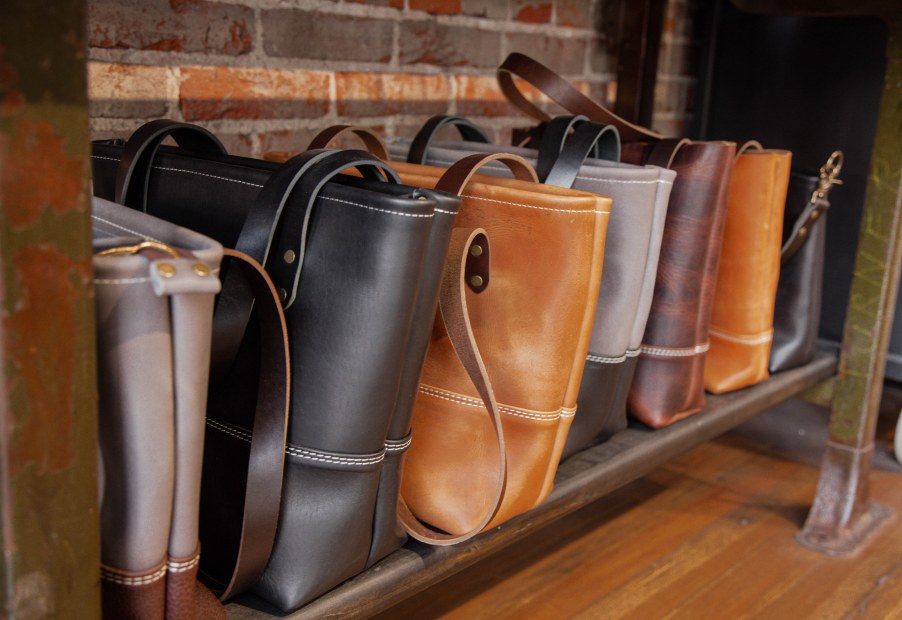 Leather bags line a shelf at Range Leather Co. in Laramie, Wyoming.