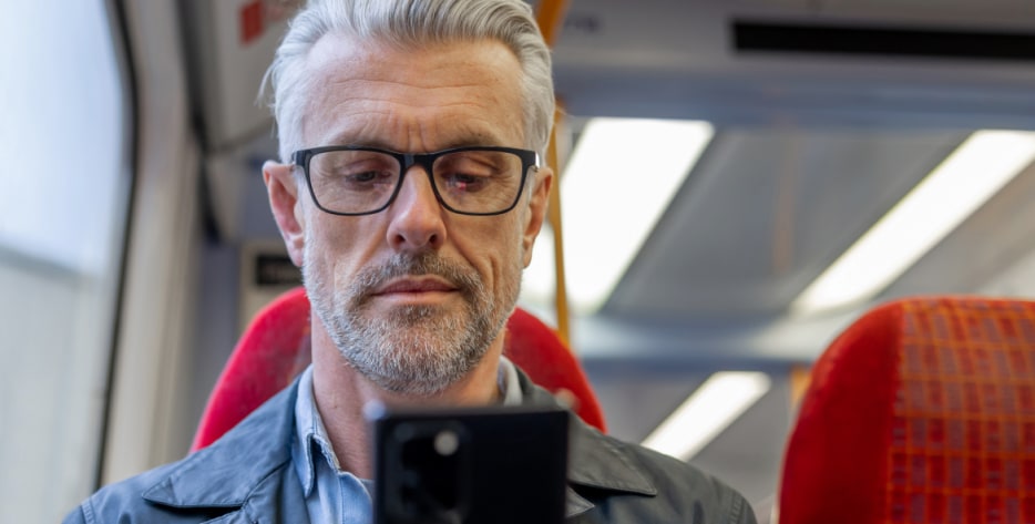 man looks at his phone after being notified of a data breach