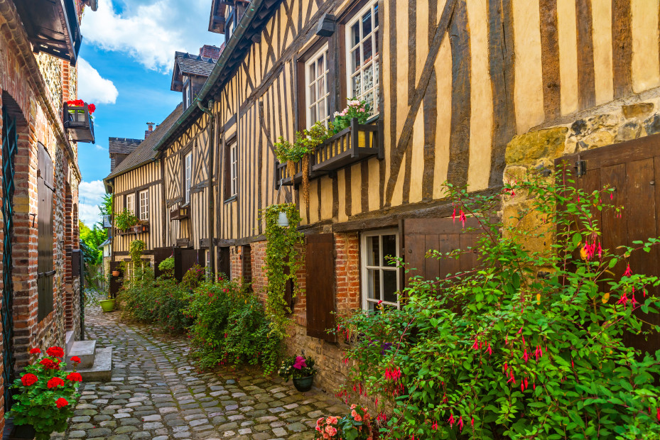 An alleyway lined with historic half-timbered buildings in Honfleur, France.