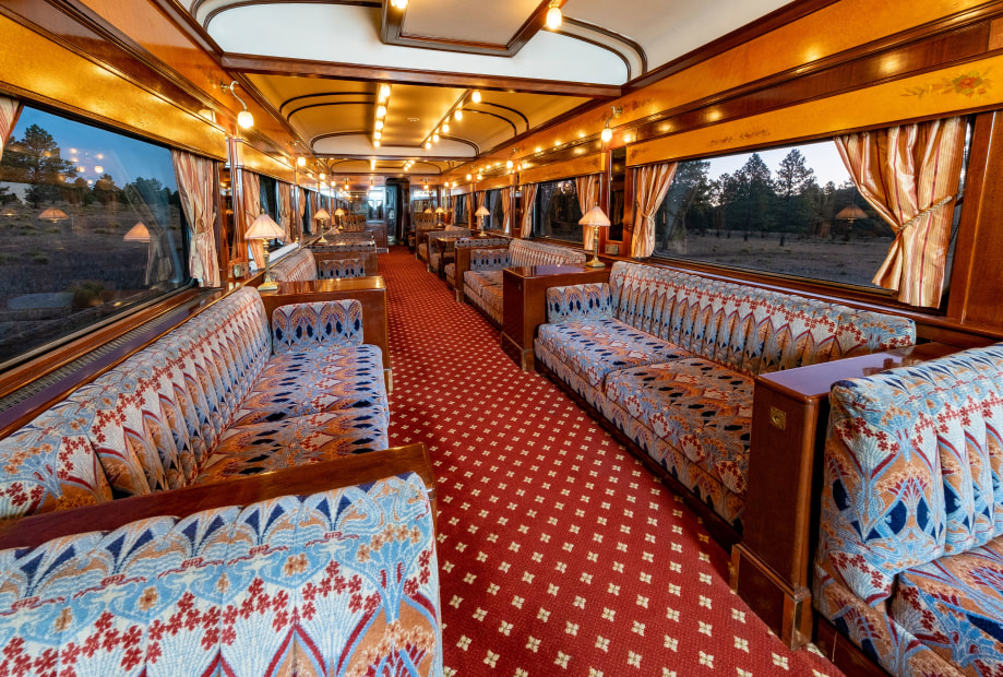 Couches and gilded lights line the interior of a historic car on the Grand Canyon Railway.