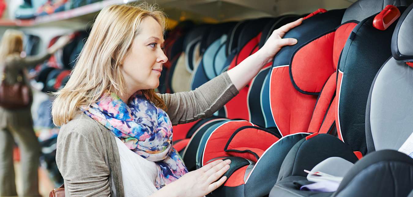 A pregnant woman shops for a child car seat