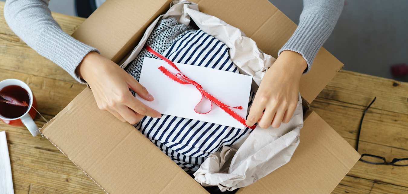 a woman packs a parcel to ship in the mail.
