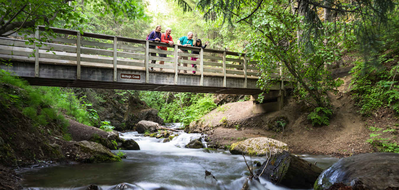 Hikers take in the views from McHugh Creek Bridge near Alaska's Turnagain Arm.