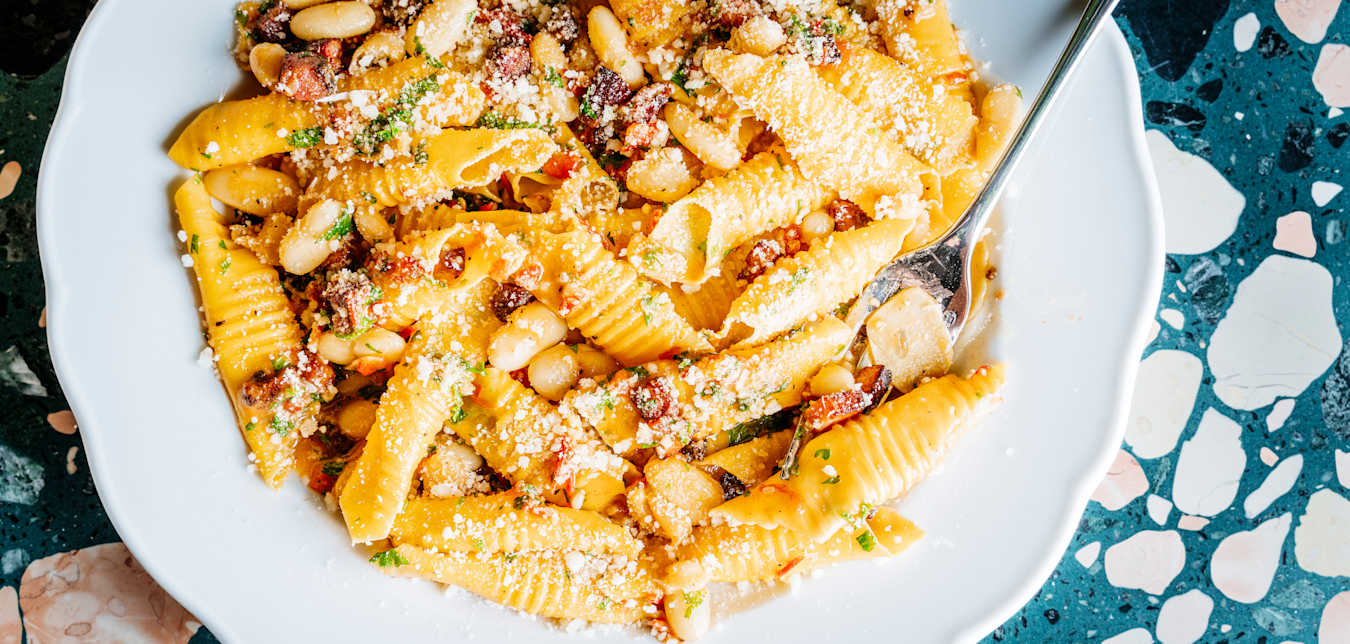 a close-up on a plate of pasta with cannellini beans with chese