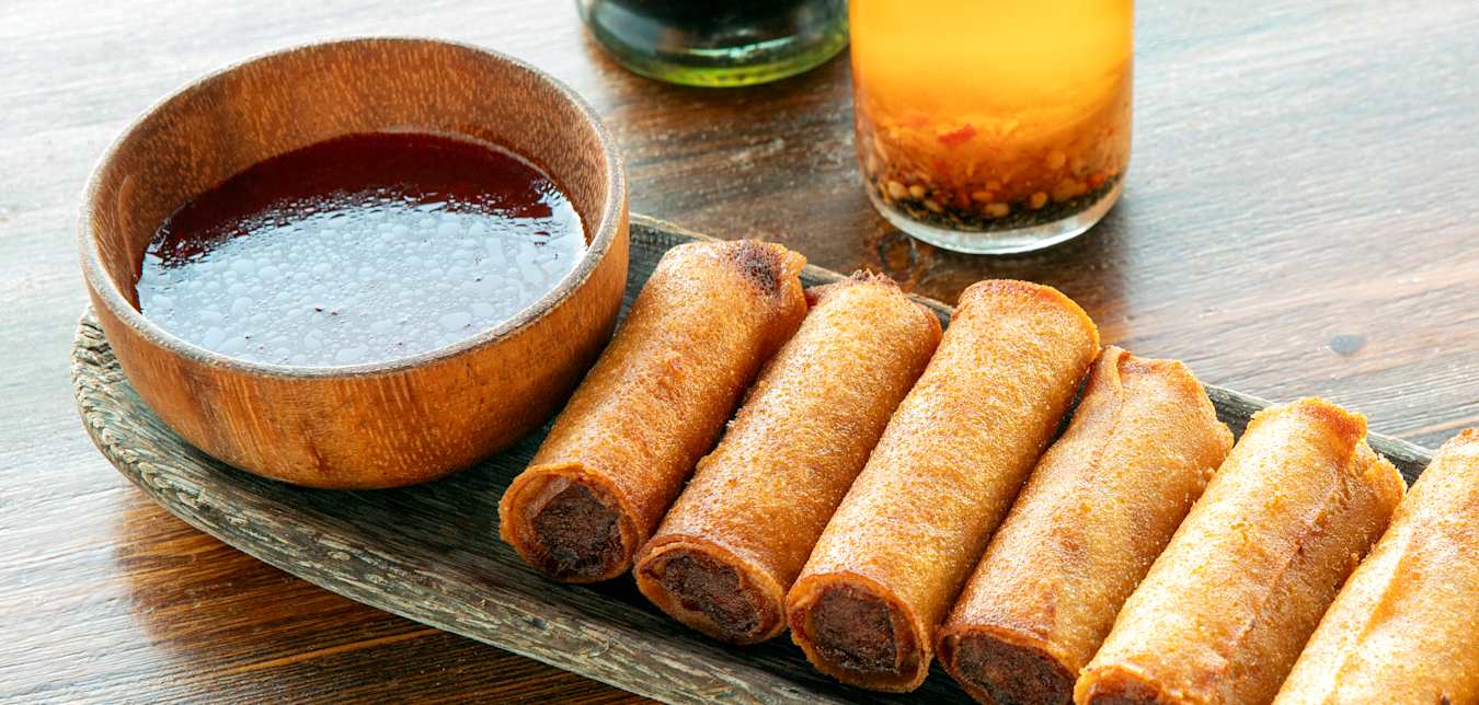 fried spring rolls on a plate with dipping sauce