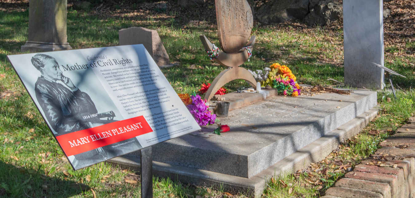 a gravestone with flowers and bracelets and a historic plaque honoring Mary Ellen Pleasant, 'California's Mother of Civil Rights'