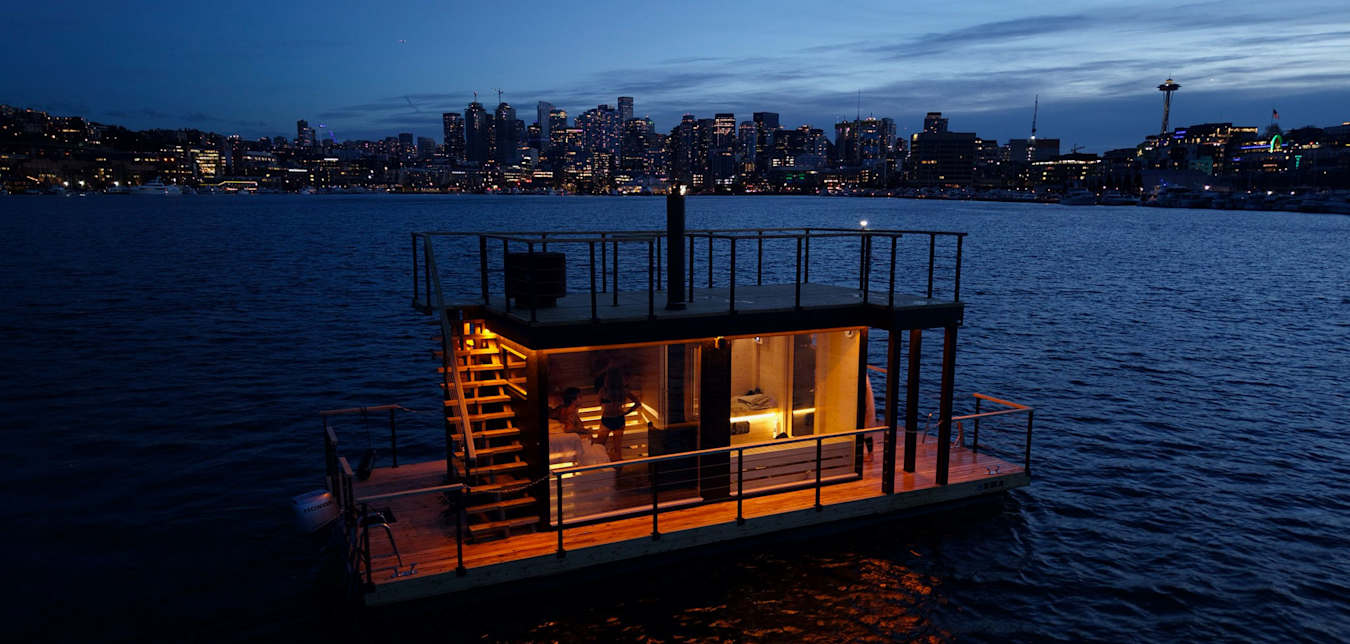 Floating Wild Haus nordic sauna on Lake Union, Washington, at dusk.