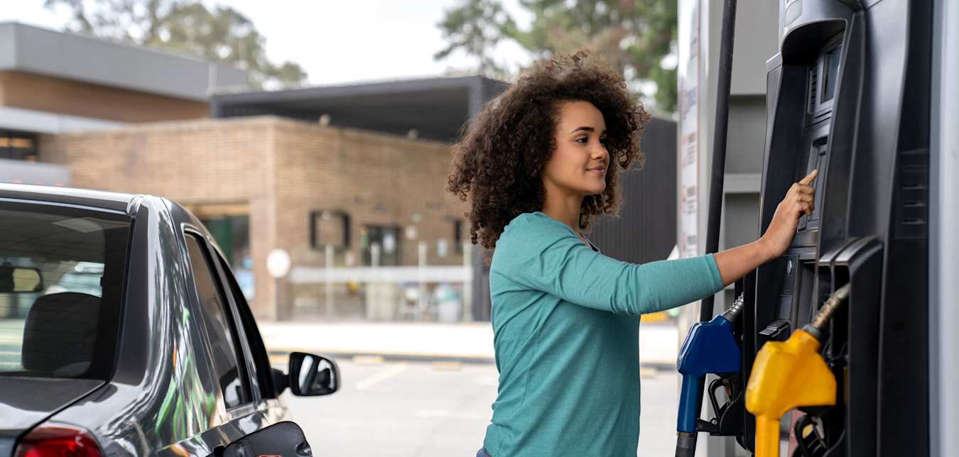 A woman selects her preferred gas at a gas station.