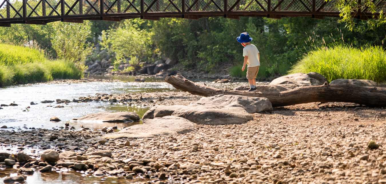 A child plays in Kendrick Park’s cool creek in Sheridan, Wyoming.