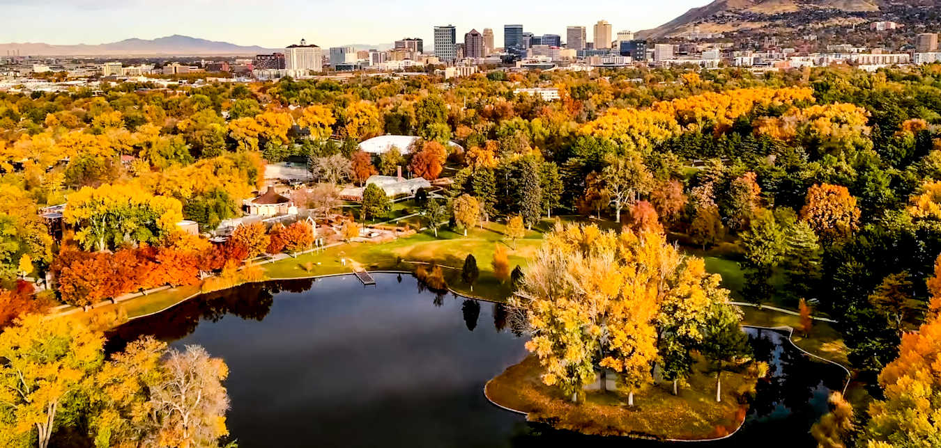 Liberty Lake surrounded by trees in fall colors at Liberty Park in Salt Lake City, Utah.