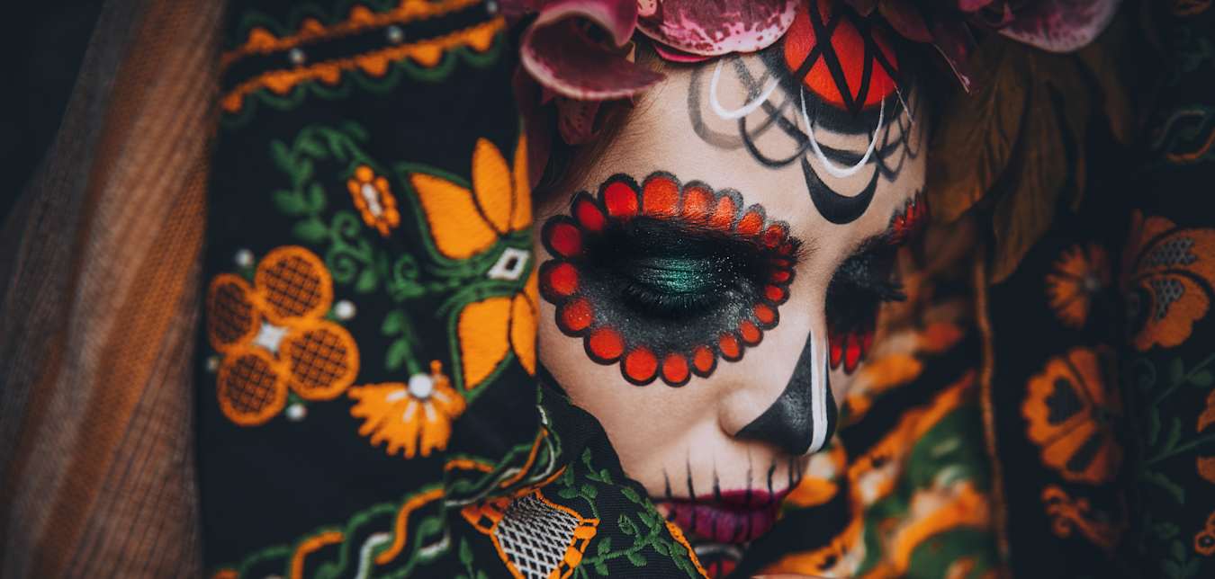 A woman with skull face painting to celebrate Dia de los Muertos.