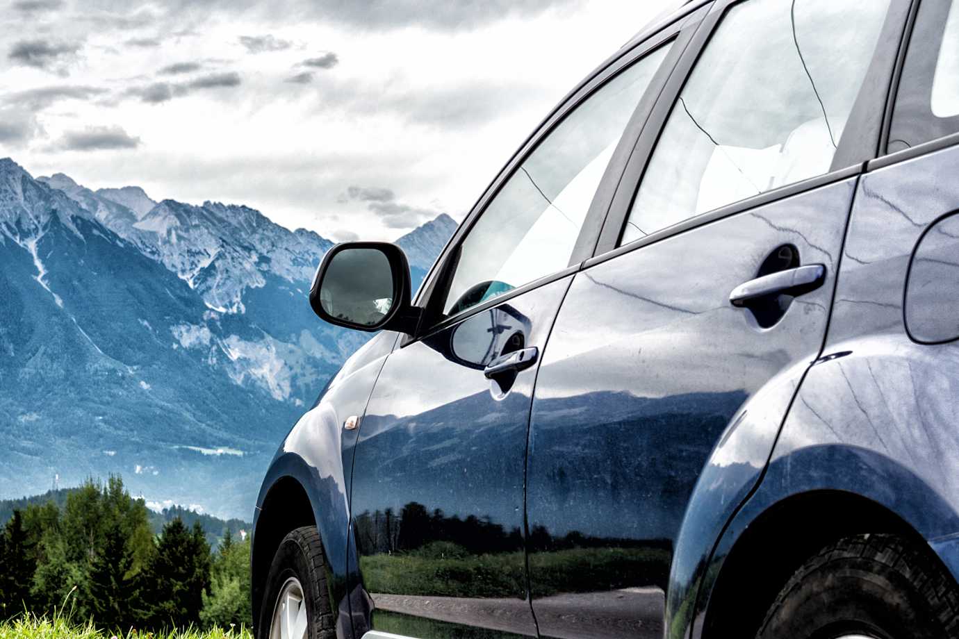 a car parked in view of beautiful mountains