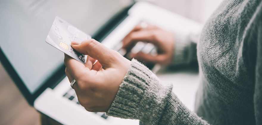 woman shopping online on laptop holding a credit card