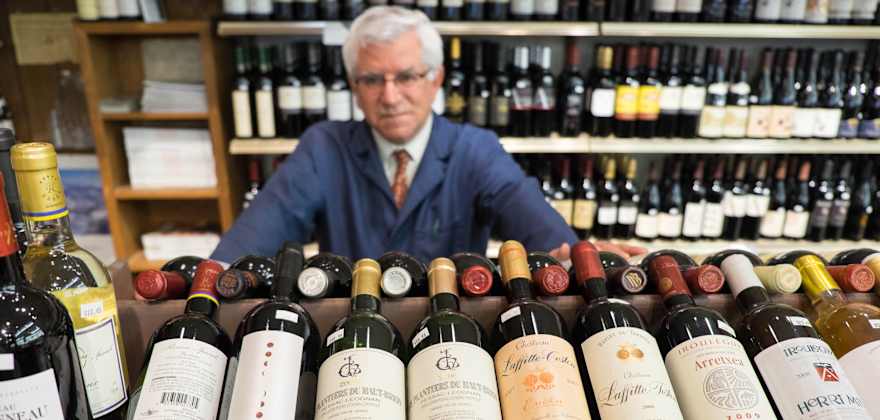 Darrell Corti with bottles of wine at Corti Bros in Sacramento, image
