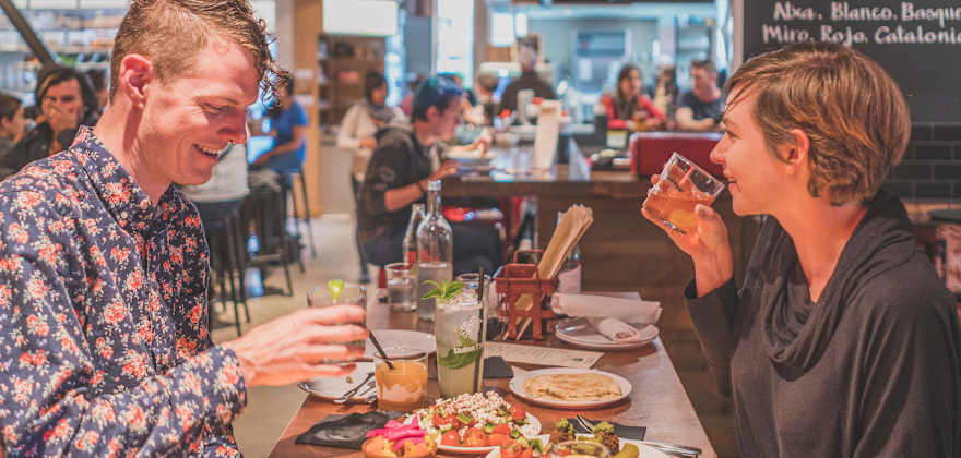 young man and woman share a meal at Pine Street Market in Portland, Oregon, picture