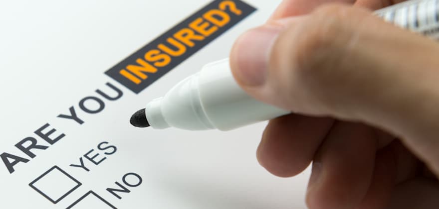 A hand with a pen getting ready to check the 'No' box to the question, Are you insured?