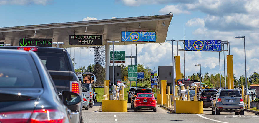 Cars wait in line at the U.S.-Canada border to drive into Canada