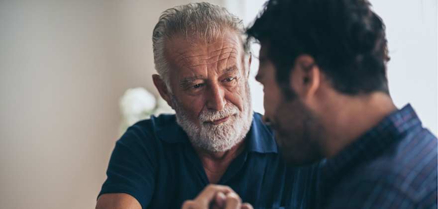 A senior man is handed car keys by a young man