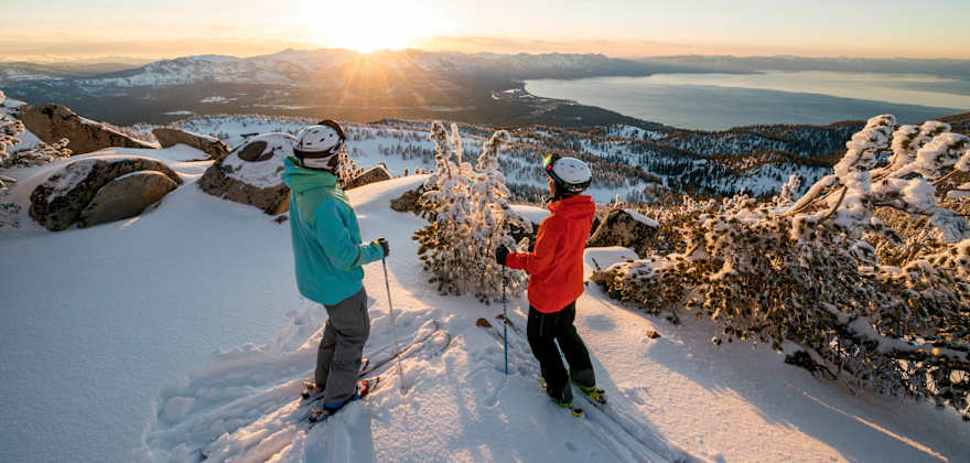 pair of skiers pause for a panoramic view of the winter scenery above Lake Tahoe, California