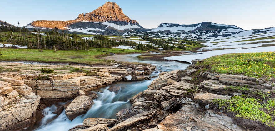 A stream cuts through Logan Pass in Montana's Glacier National Park in early summer.