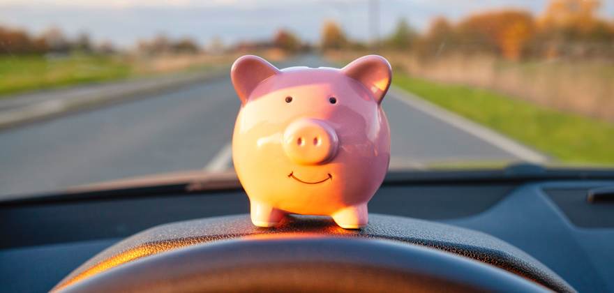 A piggy bank on the dashboard of a car