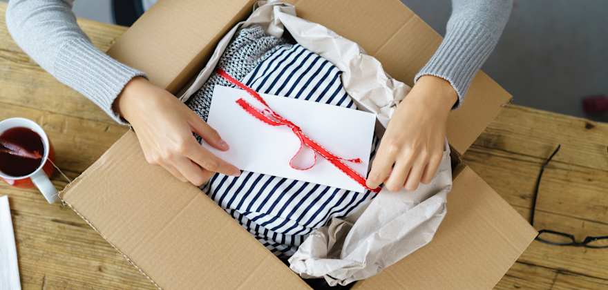 a woman packs a parcel to ship in the mail.