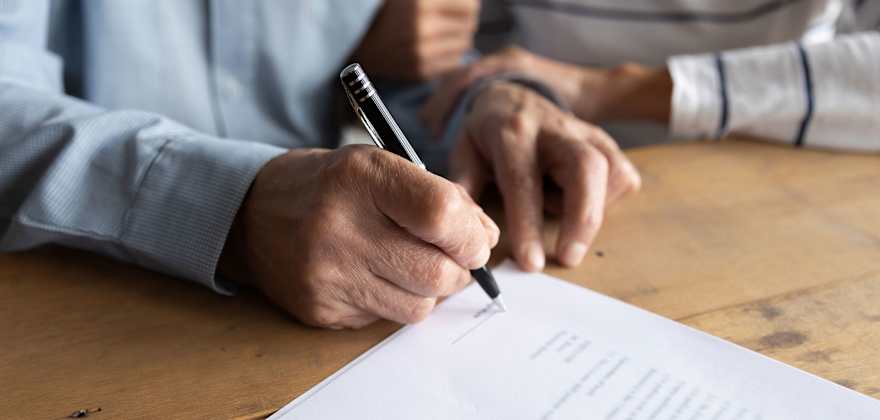 A couple signs a legal document with a notary.