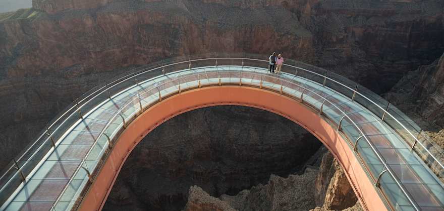 A couple stand at the center of the Grand Canyon Skywalk in Grand Canyon National Park.