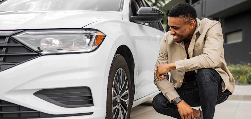 A man admires his new white car.