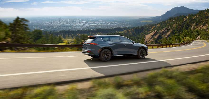 Toyota Crown Signia Hybrid driving on a hillside road.