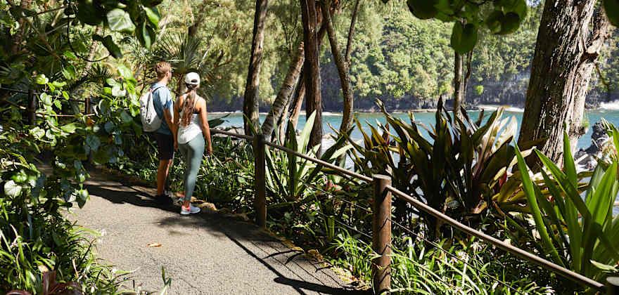 A couple walk through the Hawaii Tropical Botanical Garden.