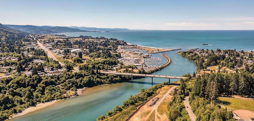 An aerial view of a river with a bridge going over it.