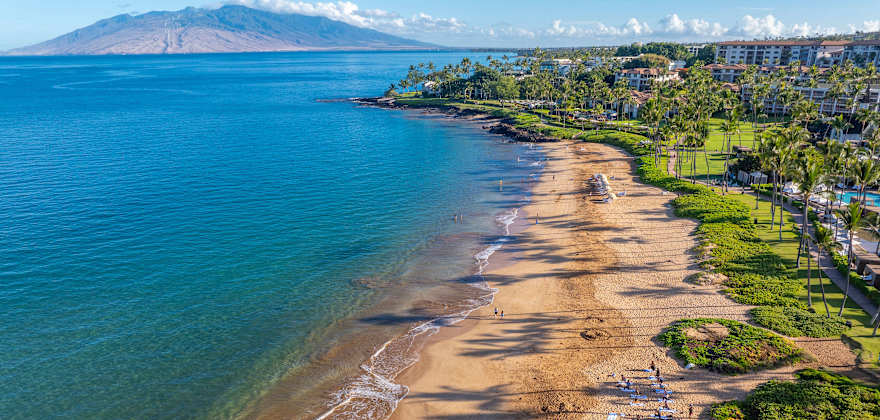 A sandy beach with views of Molokini Crater in the background