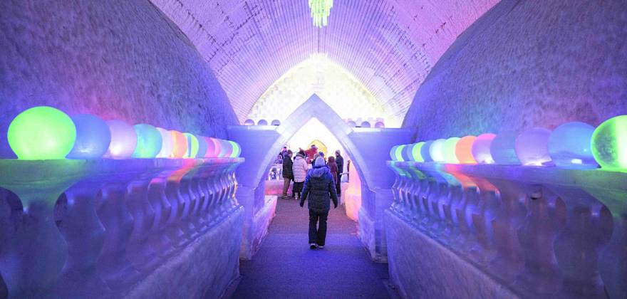 a person walks through a brightly lit ice cave