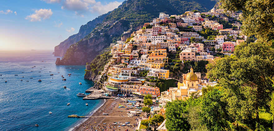 Colorful buildings hug the Amalfi Coast in Italy on a sunny day.