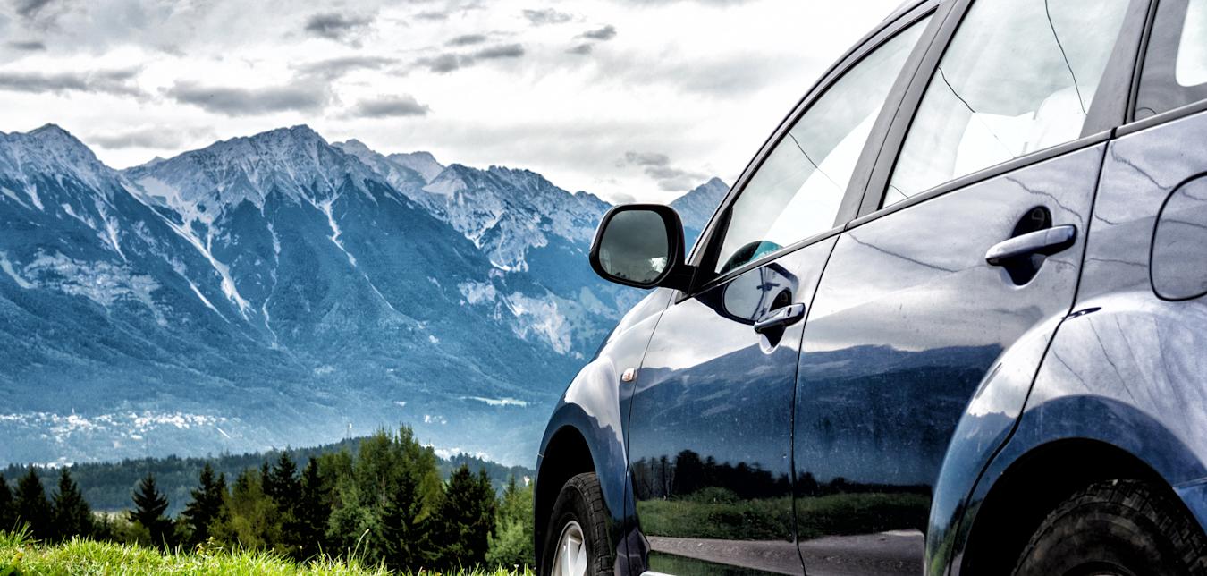 a car parked in view of beautiful mountains