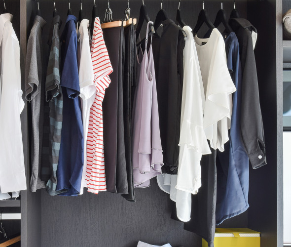 minimalist black, white, gray, and pink wardrobe hangs in an organized modern closet, image